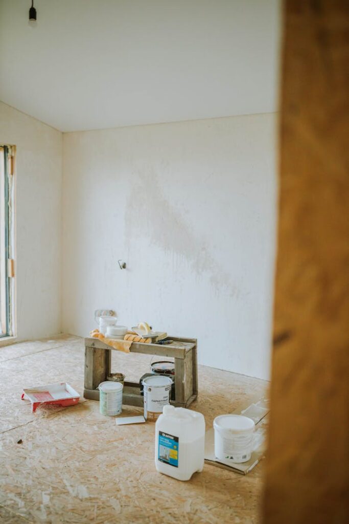 A serene room setup with paint cans and wooden crate suggests a work-in-progress renovation.